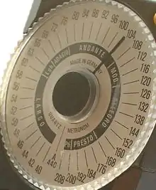 「Wittner」樣式的電子節拍器，旋轉轉盤將指針調校到需要的bpm上使用。注意內環黑底白字的義大利語速度用詞是作了非單一bpm值定義。