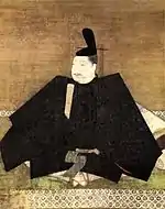 Portrait in three-quarter view of a person seated on the floor in courtly attire carrying a stick like object.