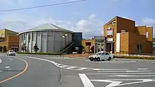 車站舊站房(圖右,2020年重開時已被新站房取代),中間圓形灰色建物為「車站廣場双葉」(2010年11月攝)