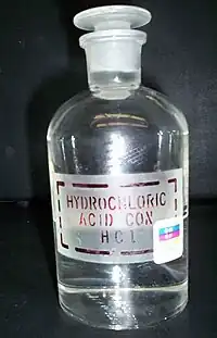 透明带有玻璃塞的玻璃瓶,上面贴着标签:“HYDROCHLORIC ACID. COX. HCl”