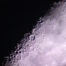 在被太阳部分照亮的新月时分,一位业余天文学家在后院用望远镜拍摄的月球陨石坑。