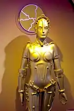 A replica of a gold-plated feminine robot.