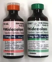 两个标有咪达唑仑的10毫升瓶。左边的瓶子上有一个红色的标签,上面写着1 mg/ml;右边那个是绿色的,上面写着5 mg/ml。两个瓶子都印有很多精美的字样。
