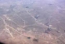 朱日和訓練基地：右侧近景基地主体建筑群属旗府赛汉塔拉镇所辖哈登胡舒嘎查，左侧的跑道属朱日和镇巴彦塔拉嘎查，远景主体训练区属四子王旗白音朝克图镇。