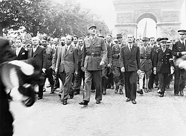 1944年8月26日，夏爾·戴高樂將軍率領慶祝巴黎解放的閱兵式。馬塞爾·弗盧雷（英语：）是右數第二位人士。