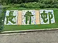 凹板印刷風格的邨名花圃，位於青楊樓斜坡